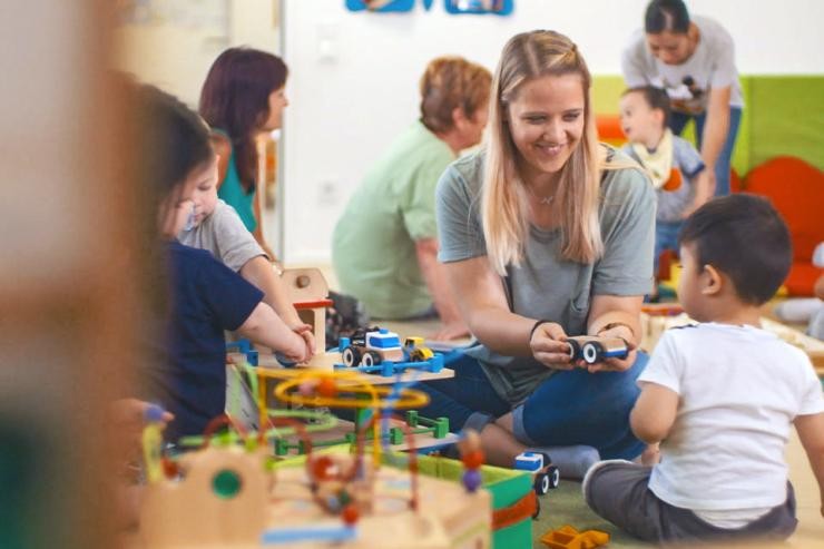 Praxissituation Soziale Arbeit in der Elementarpädagogik Studierende spielt mit Kindern im Familientree