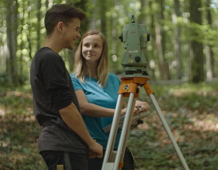 Vermessungstechniker*in Landratsamt Göppingen zwei Auszubildene im Wald mit Messtechnik